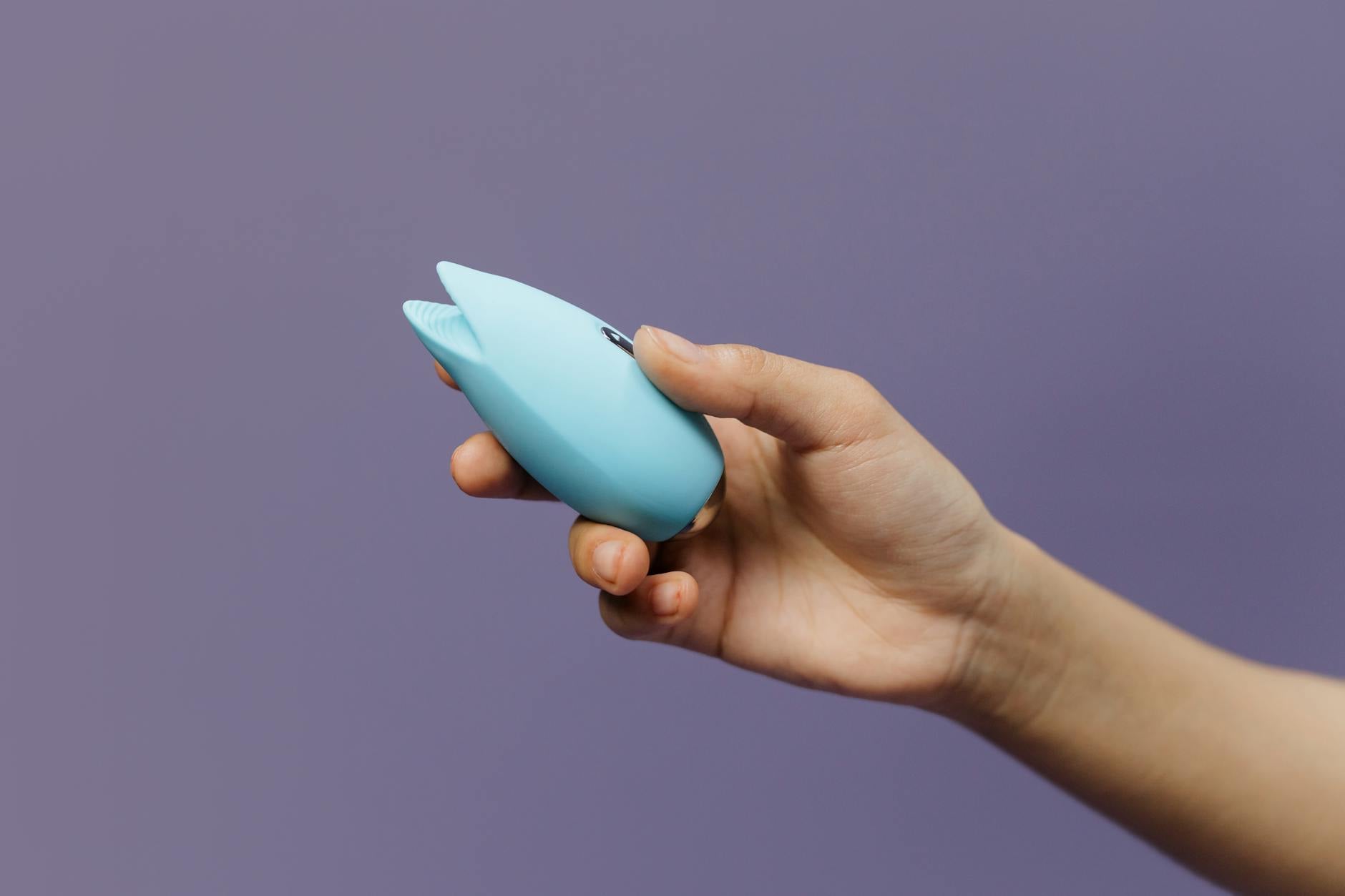 A blue silicone vibrator held in hand, representing intimate tools for rebuilding foreplay and connection