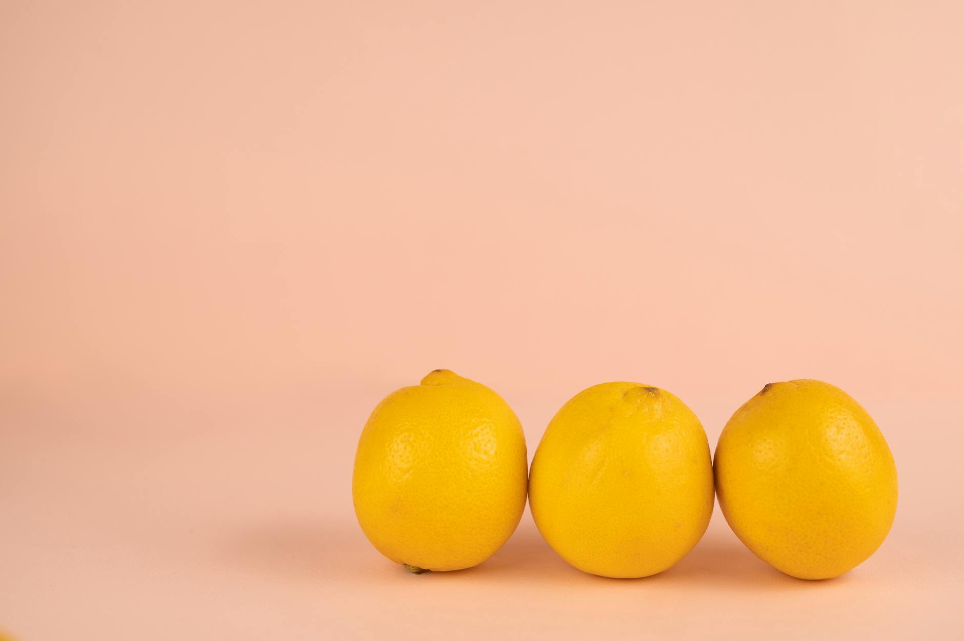 Close-up of hands holding a sleek lemon clitoral vibrator against a soft background
